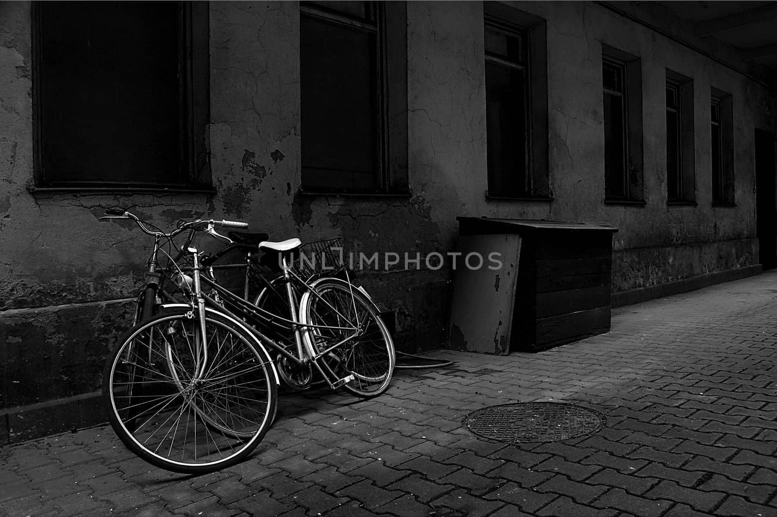 Vintage bikes over old wall. Black and white.