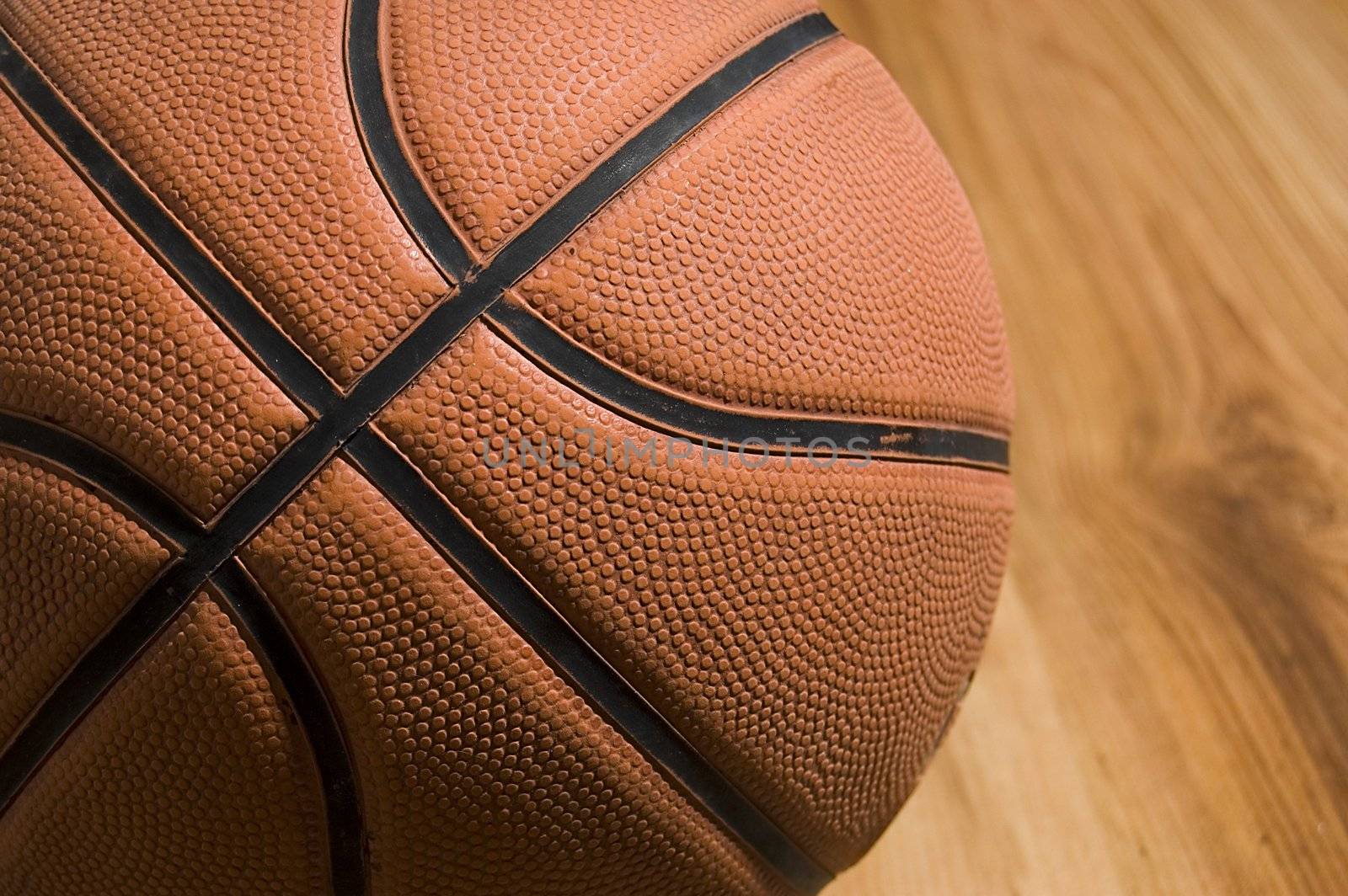 Basketball over wooden floor. Close up.