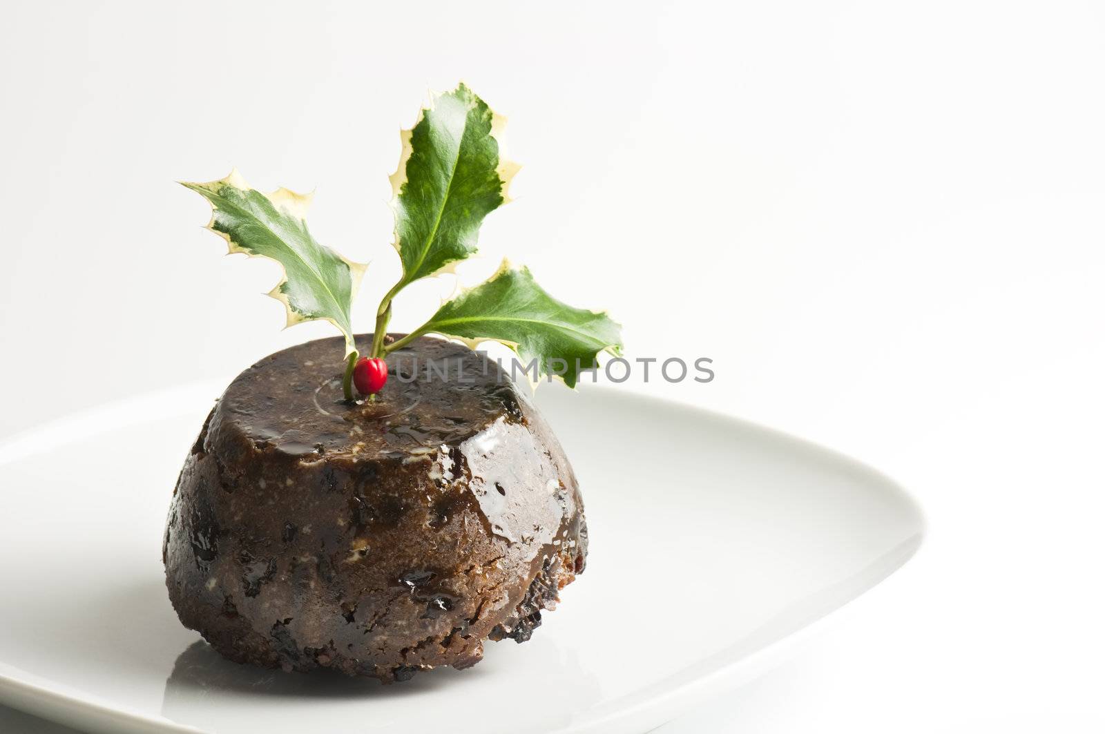 Traditional english Christmas pudding with holly leaves