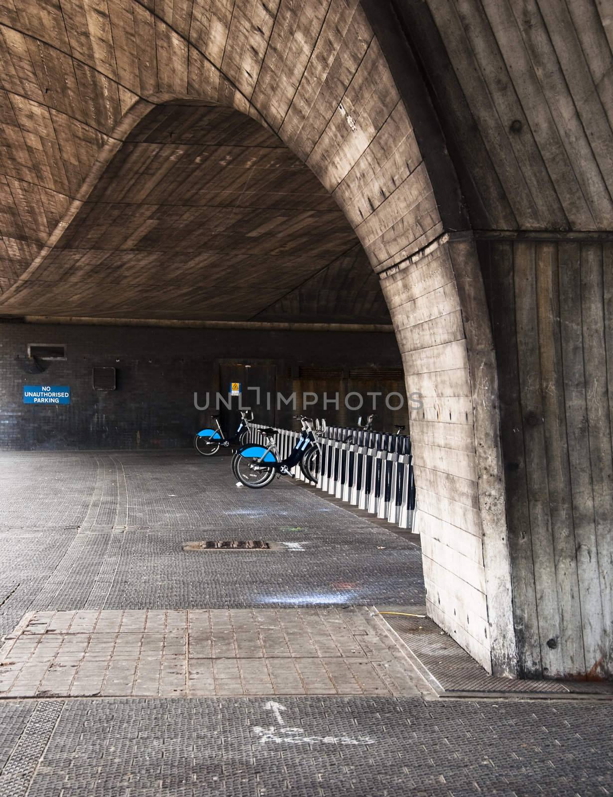 Public rental bicycle station under a bridge in London, UK