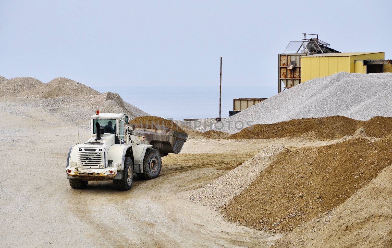 A white bulldozer moving gravel