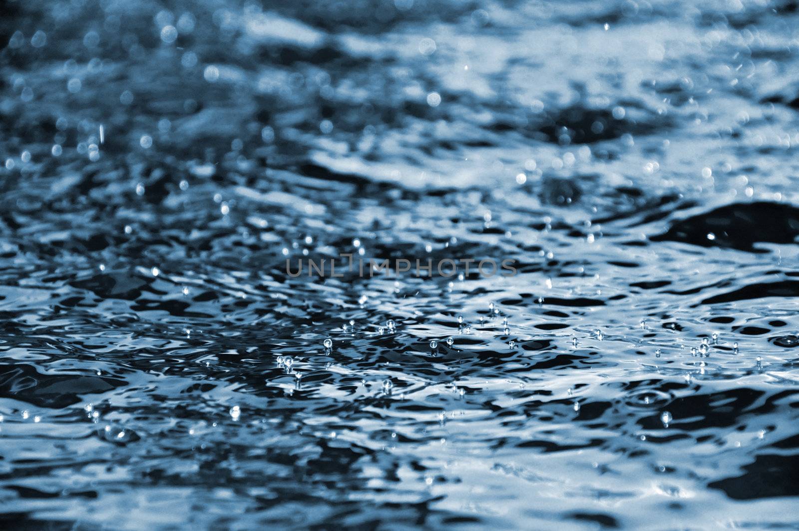 Water droplets floating on the dark blue water surface