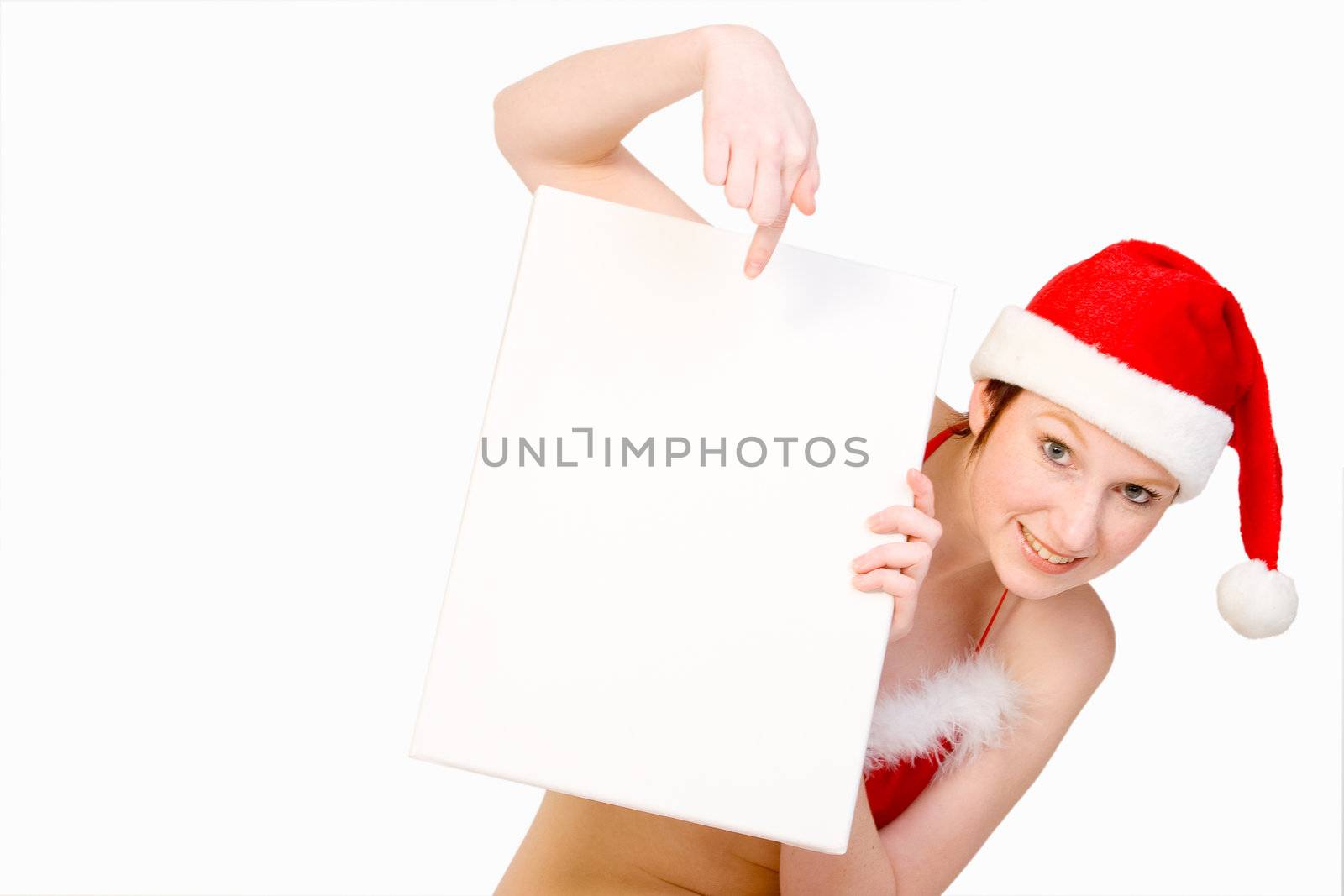 Beautifull girl in christmas bikini and with christmas hat is hlding up a white sign for copy space. With background clipping path for your convenience