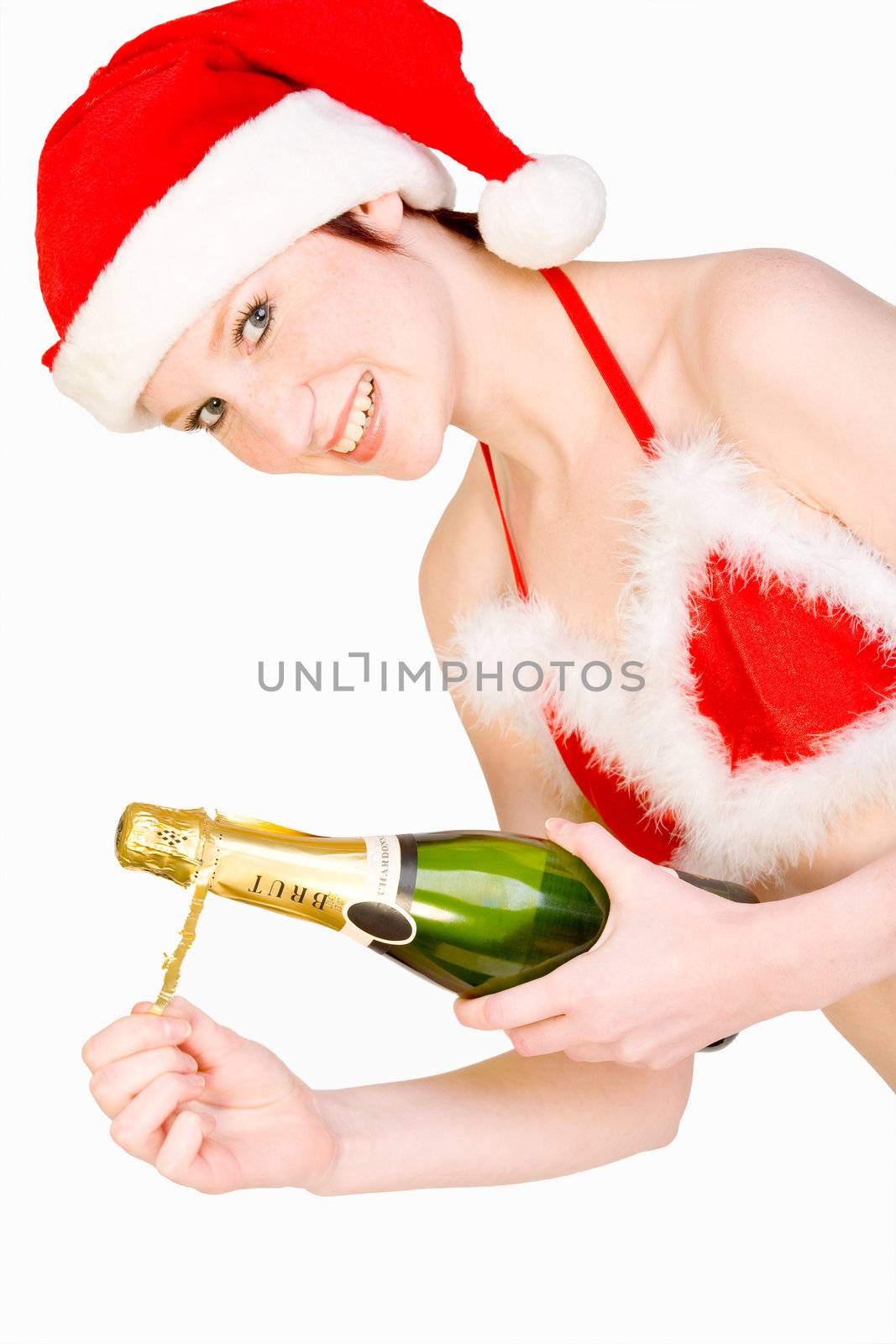 Beautifull girl in christmas bikini and with christmas hat is presenting a bottle of champagne. With background clipping path for your convenience