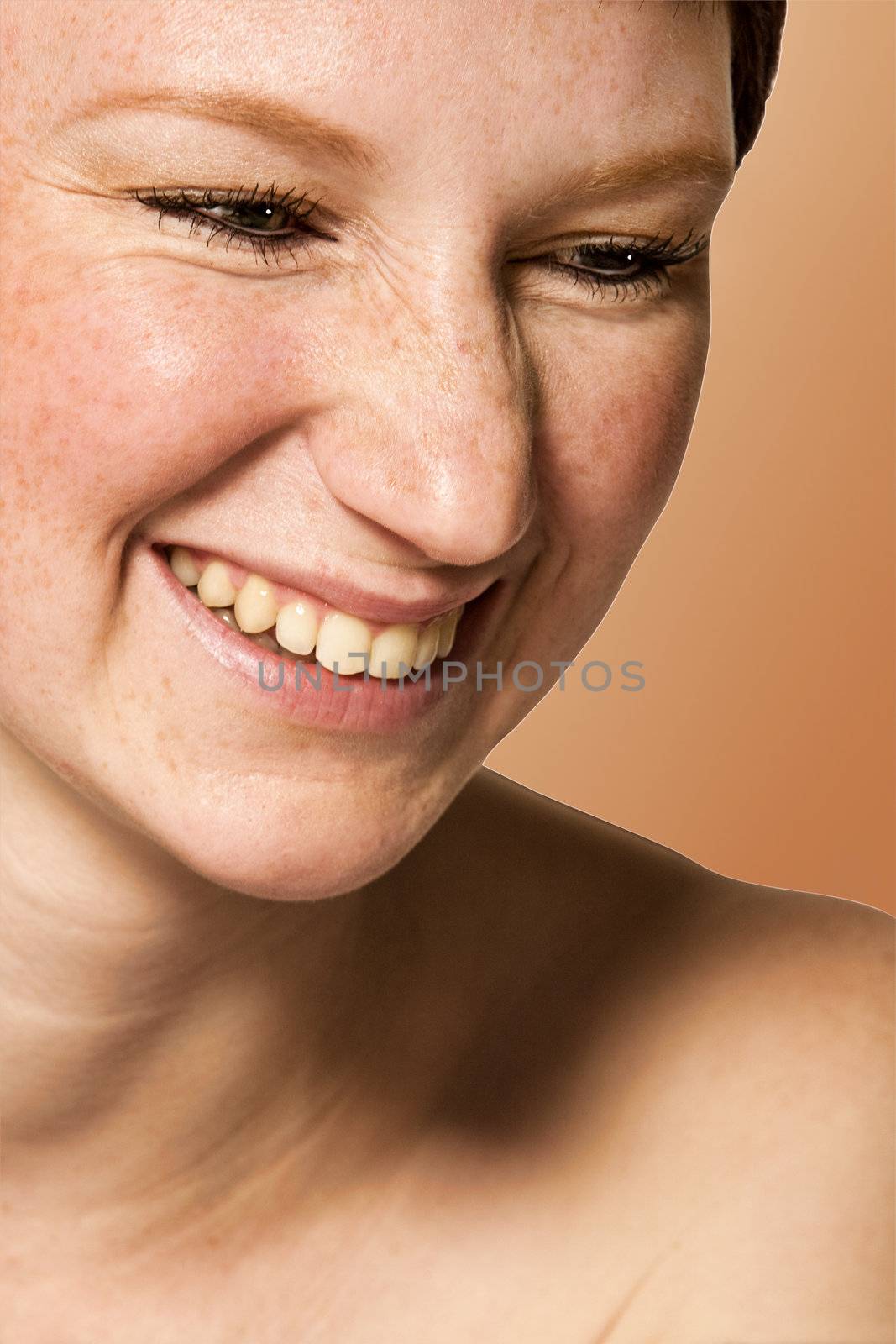 Studio portrait of a young woman with short hair in laughs