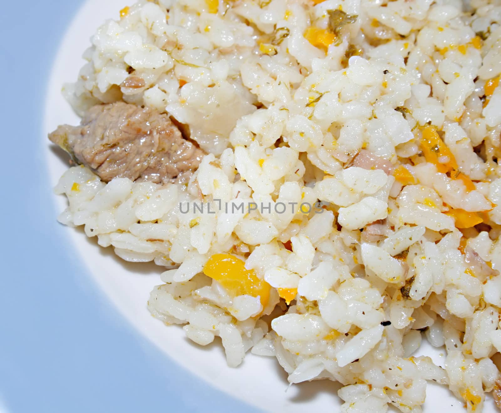 dish of pilau from rice, meat and vegetables, with spicinesses on a white background