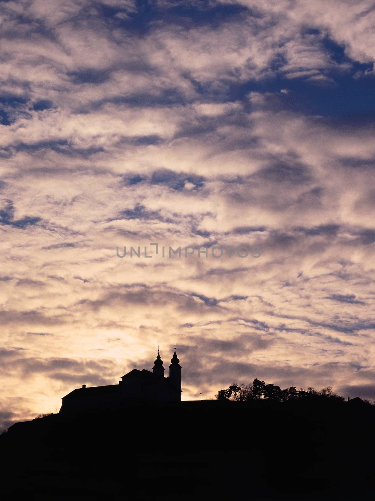 The silhouette of Tihany abbey in front of a dramatic cloudy sky. The picture was scanned from a 35 mm slide.