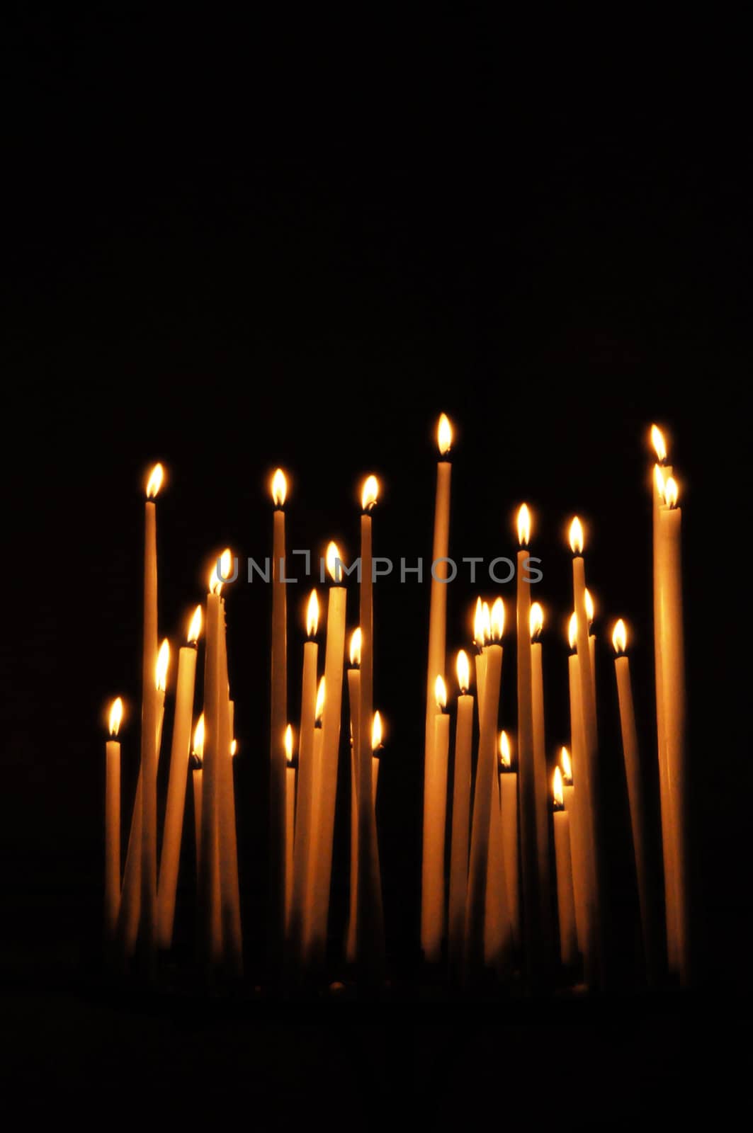 Candles in a church, black background