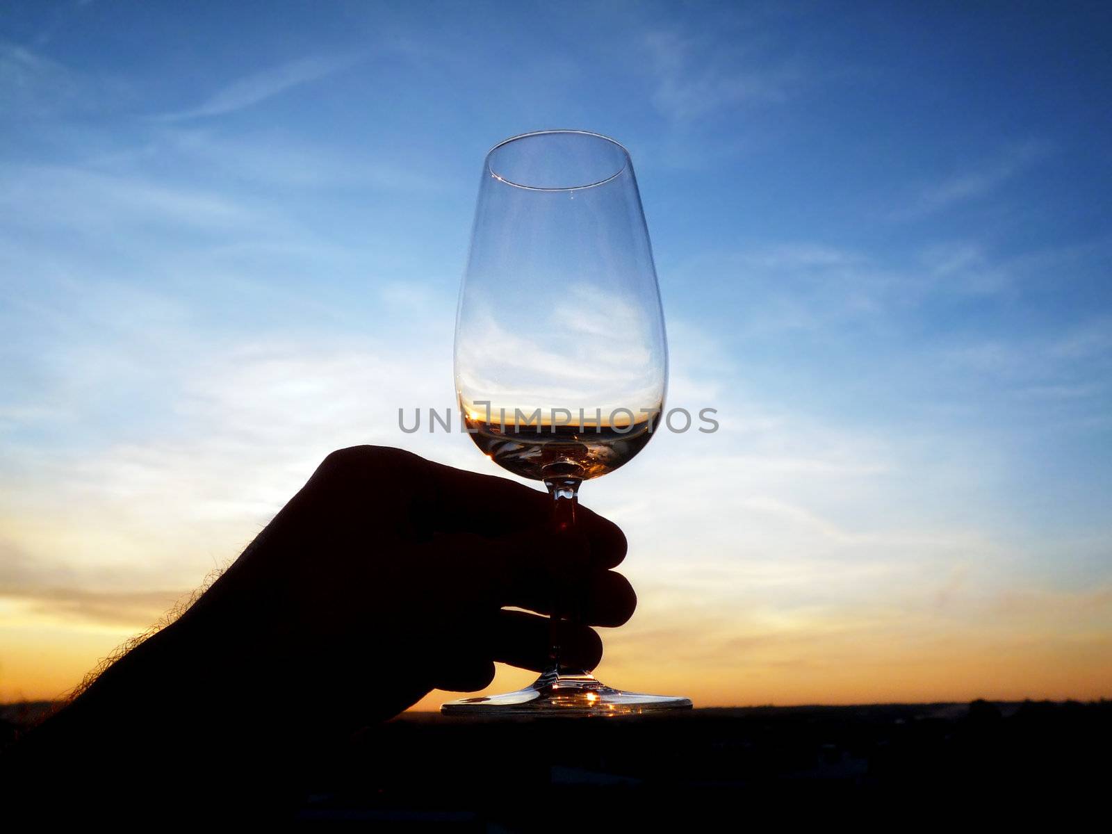 An empty glass of wine at sunset