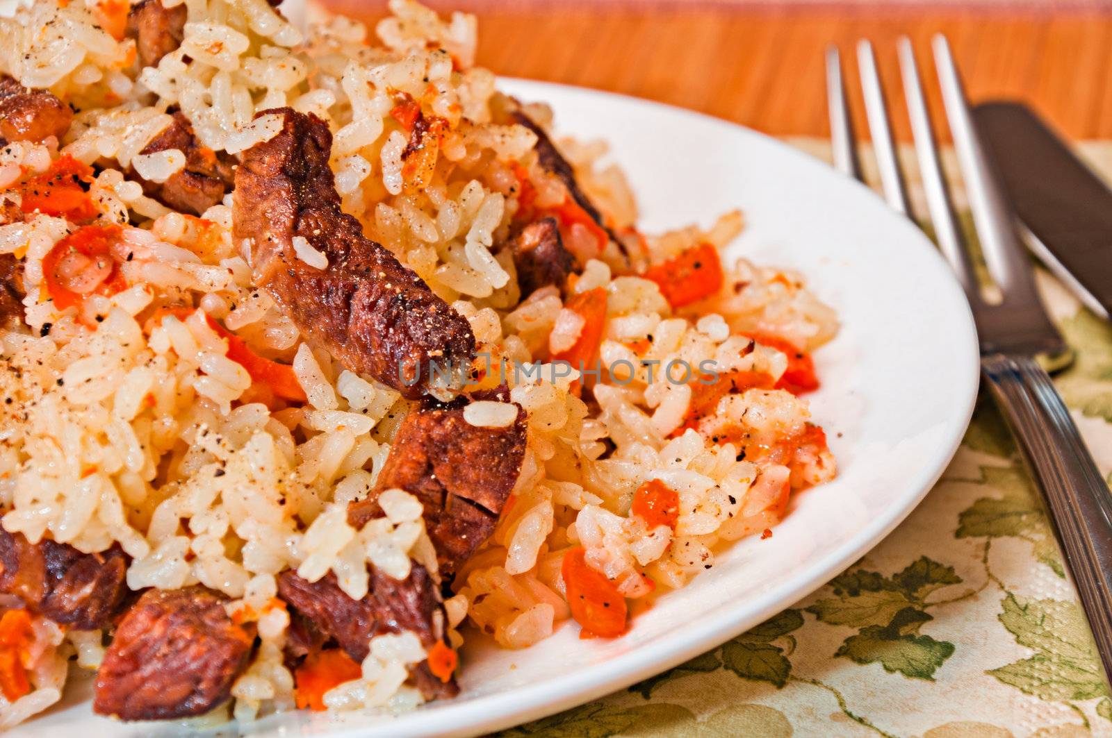 Pilaf made ​​of rice, fresh carrots, dried fruits and meat.