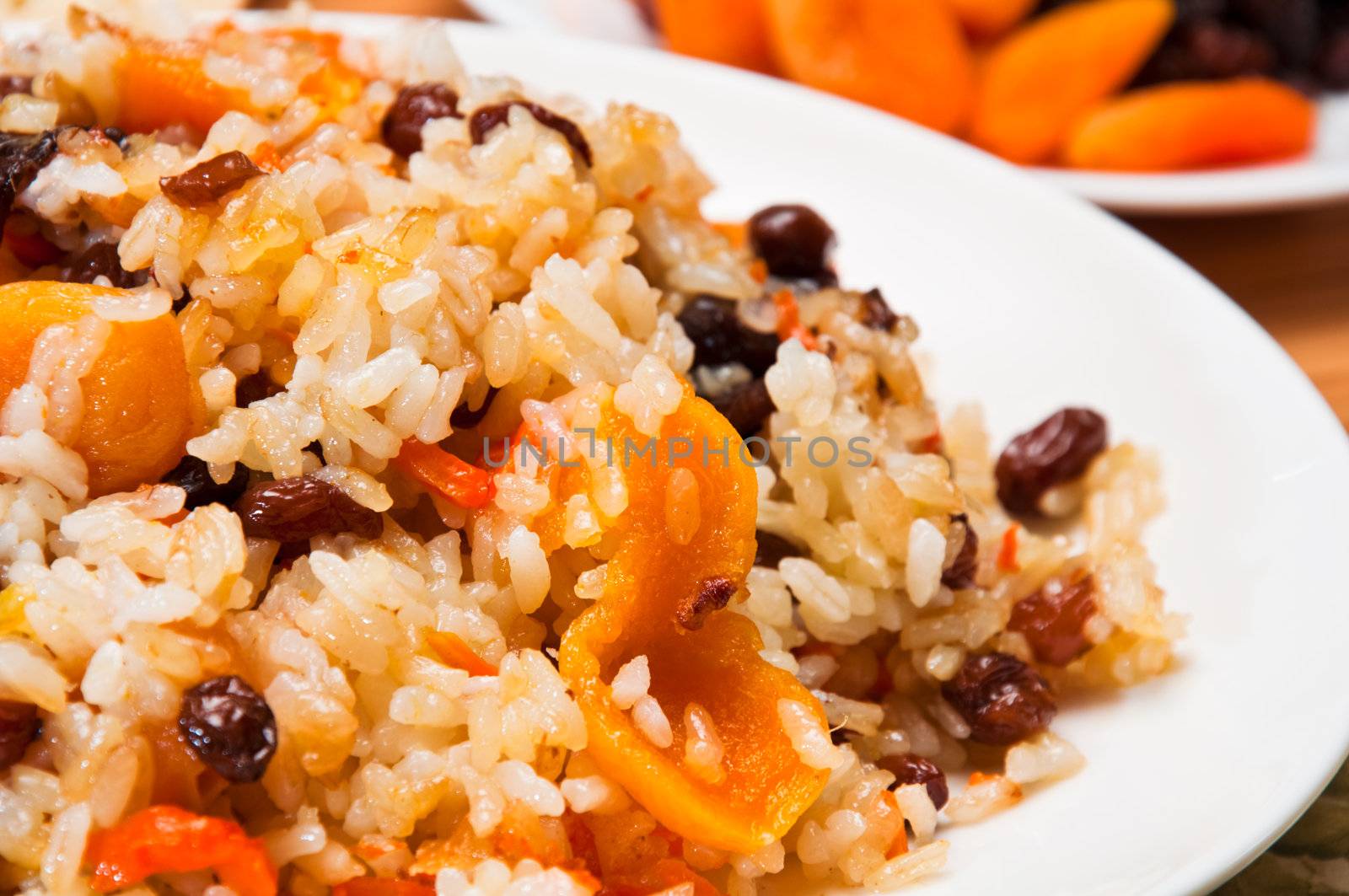 Pilaf made ​​of rice, fresh carrots and dried plums, grapes, apricots.