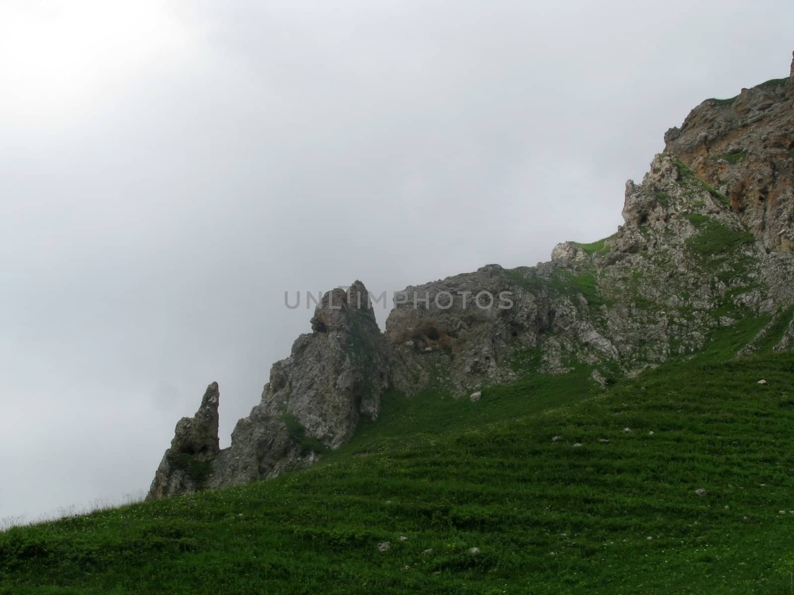 Mountains; rocks; a relief; a landscape; a hill; a panorama; Caucasus; top; a slope; clouds; the sky; a landscape