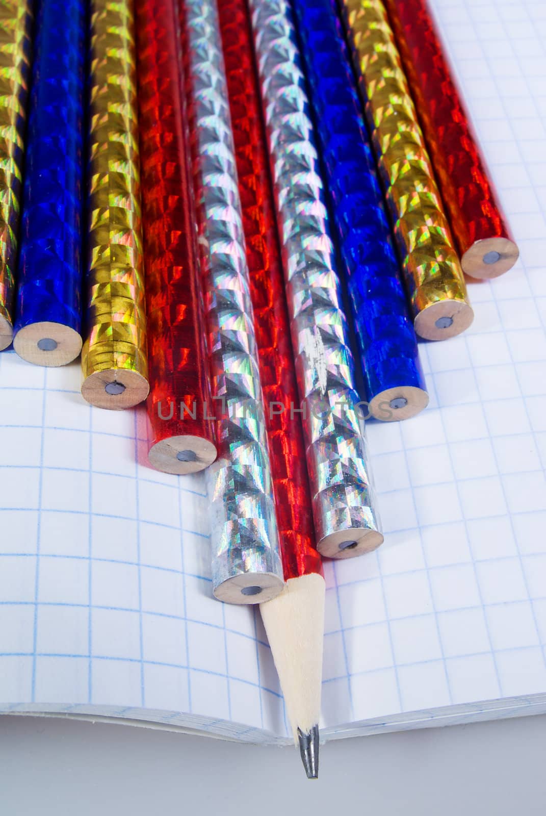 Multi-colored pencils on a writing-book
