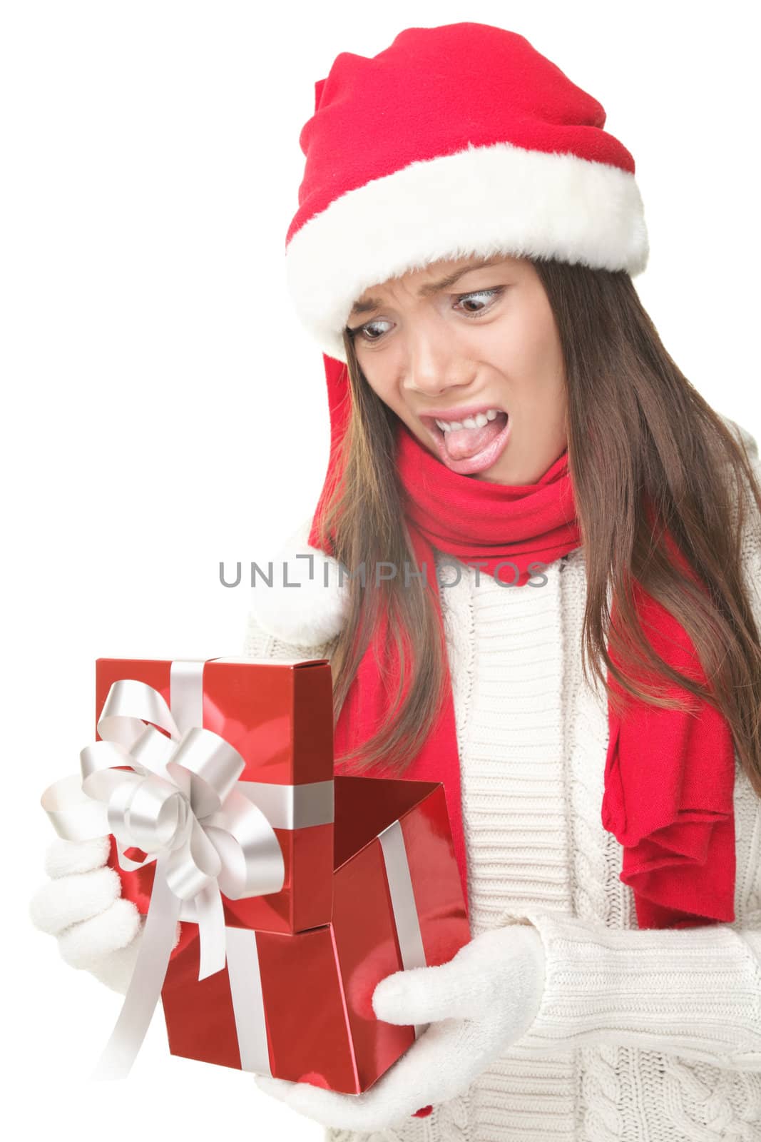 Christmas Gift - woman opening gift disappointed and unhappy, Young woman in Santa hat. Funny cute photo of Asian / Caucasian woman isolated on white background. 