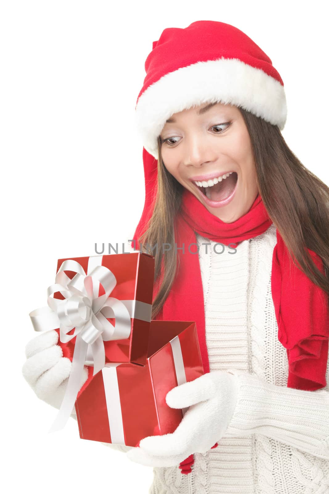 Christmas Gift - woman opening gift surprised and happy, Young beautiful smiling woman in Santa hat. Funny cute photo of Asian / Caucasian woman isolated on white background
