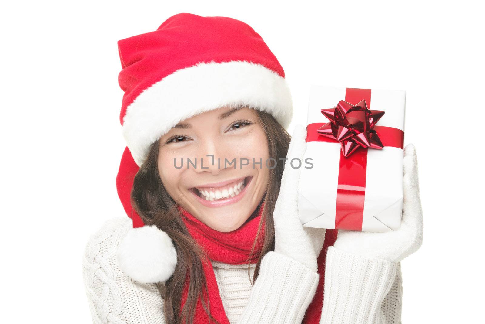 Santa woman showing gift wearing Santa hat. Christmas woman portrait of a cute, beautiful smiling mixed Asian / Caucasian model. Isolated on white background. 