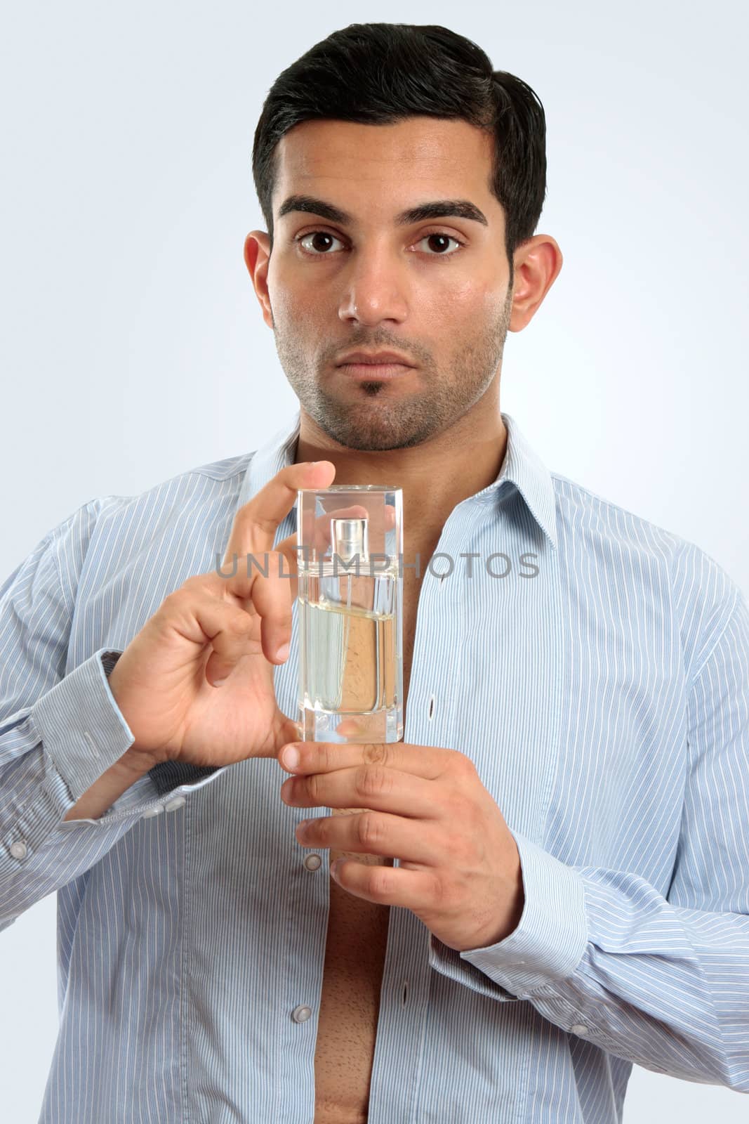 Man holding glass bottle men's cologne by lovleah