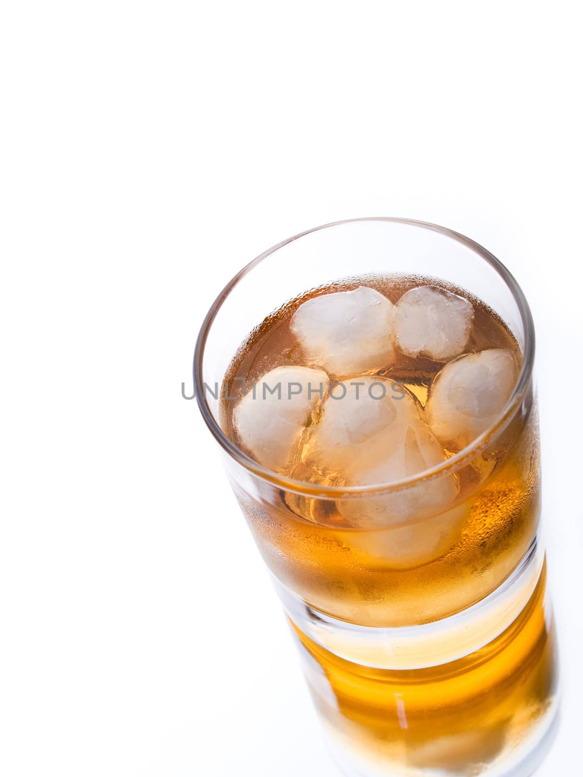 Glass of whiskey and ice on white