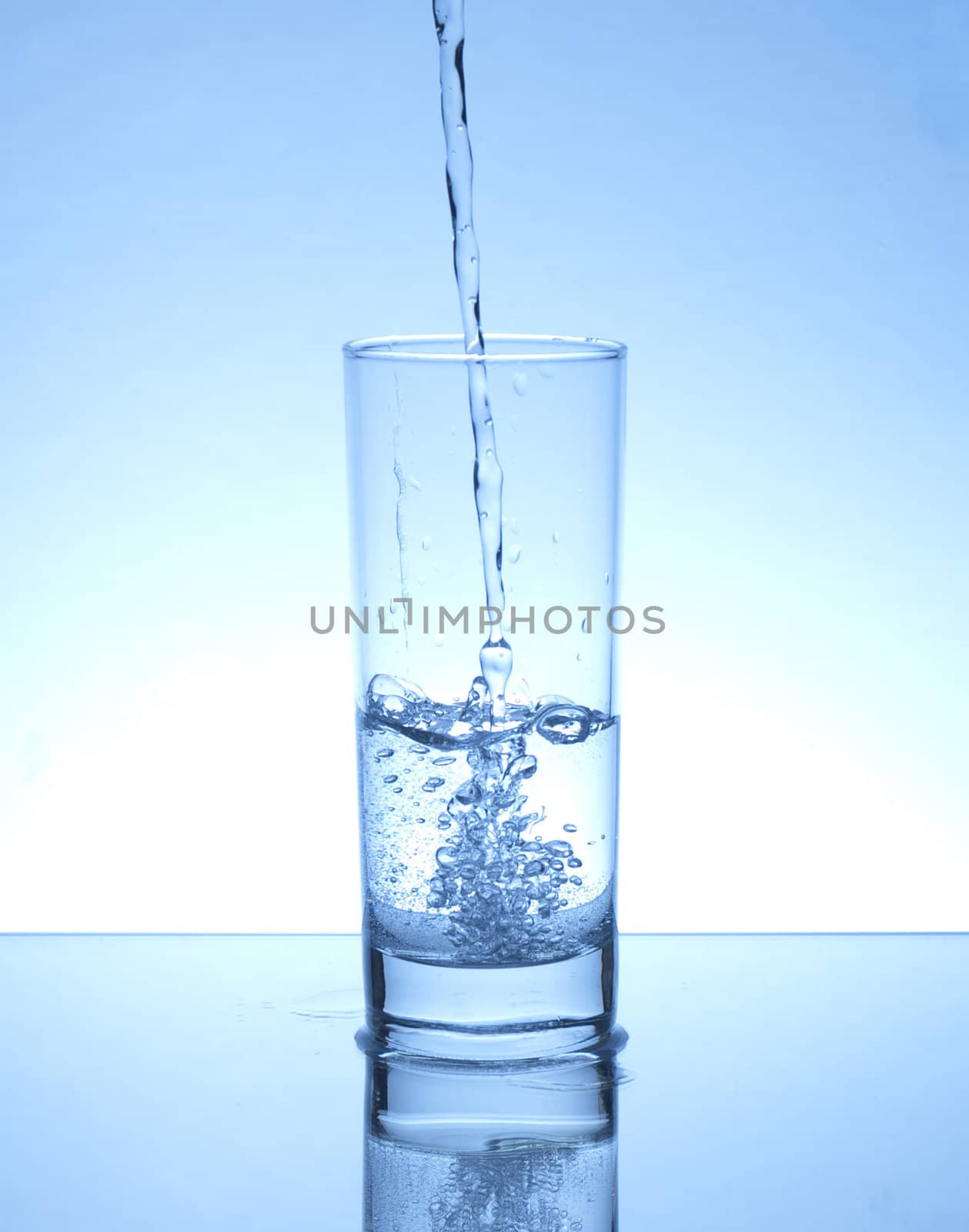 Glass of water on blue background