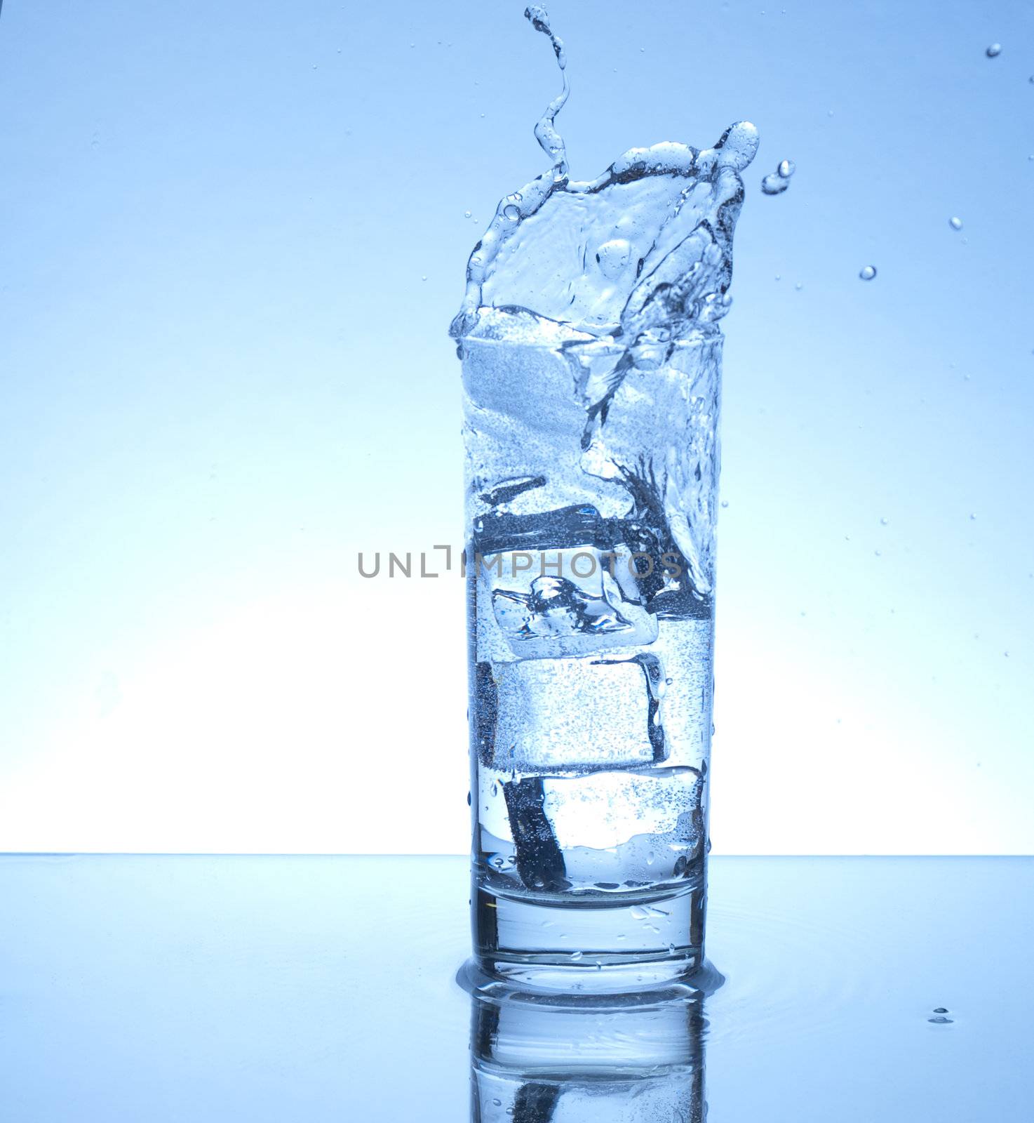 ice cube entering glass of water with a splash