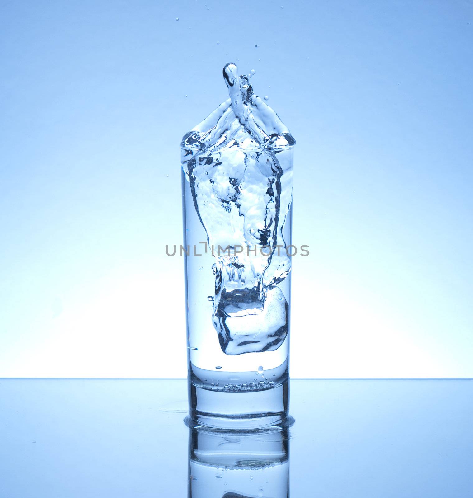 Ice cube dropped in a glass of water