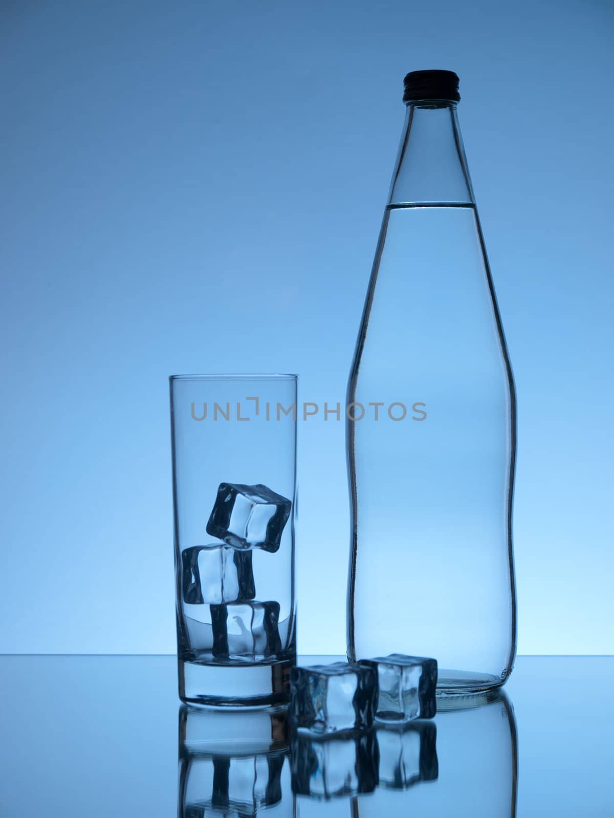 Ice cubes, glass and water bottle