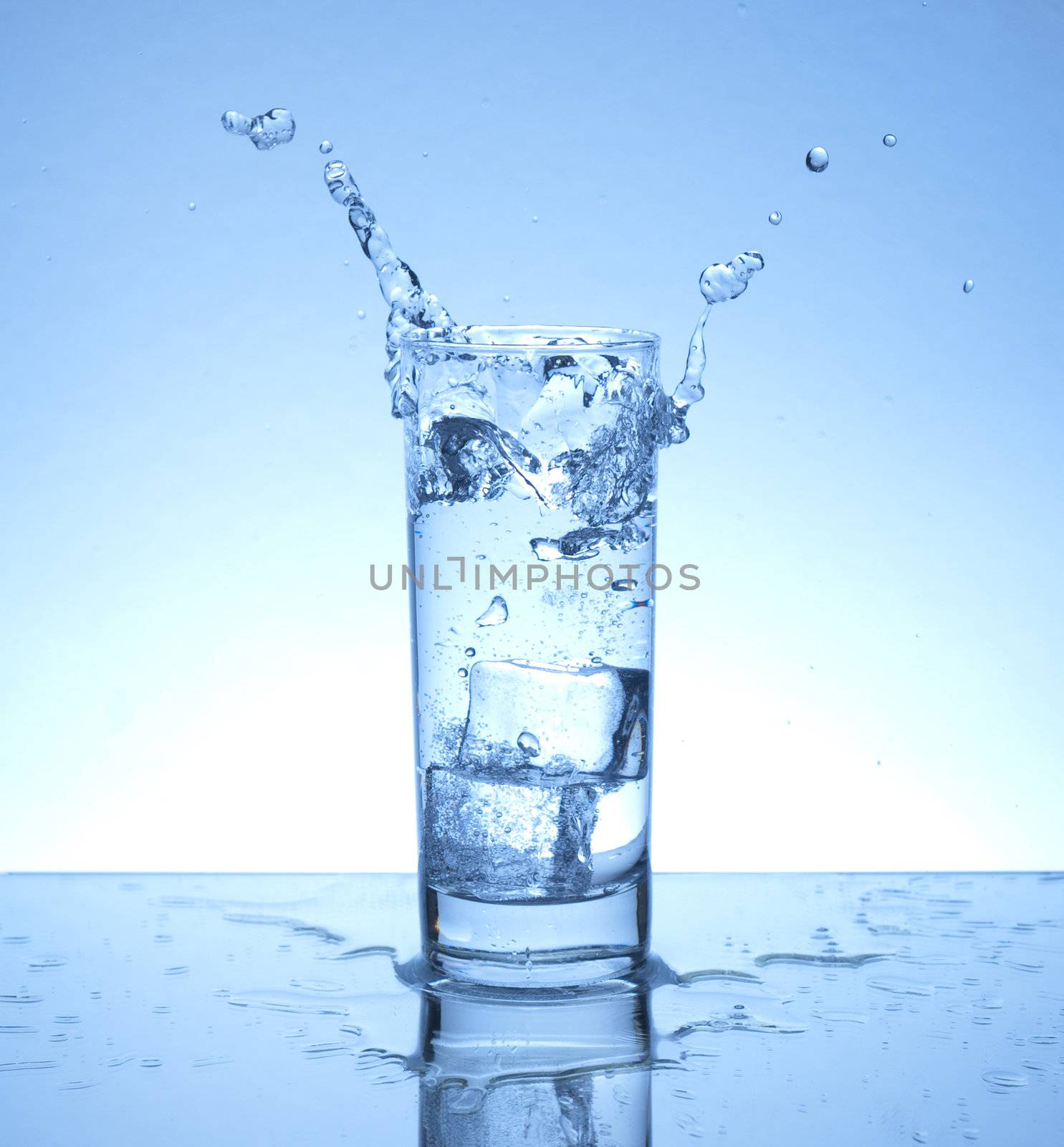 Ice cubes falling in a glass of waer