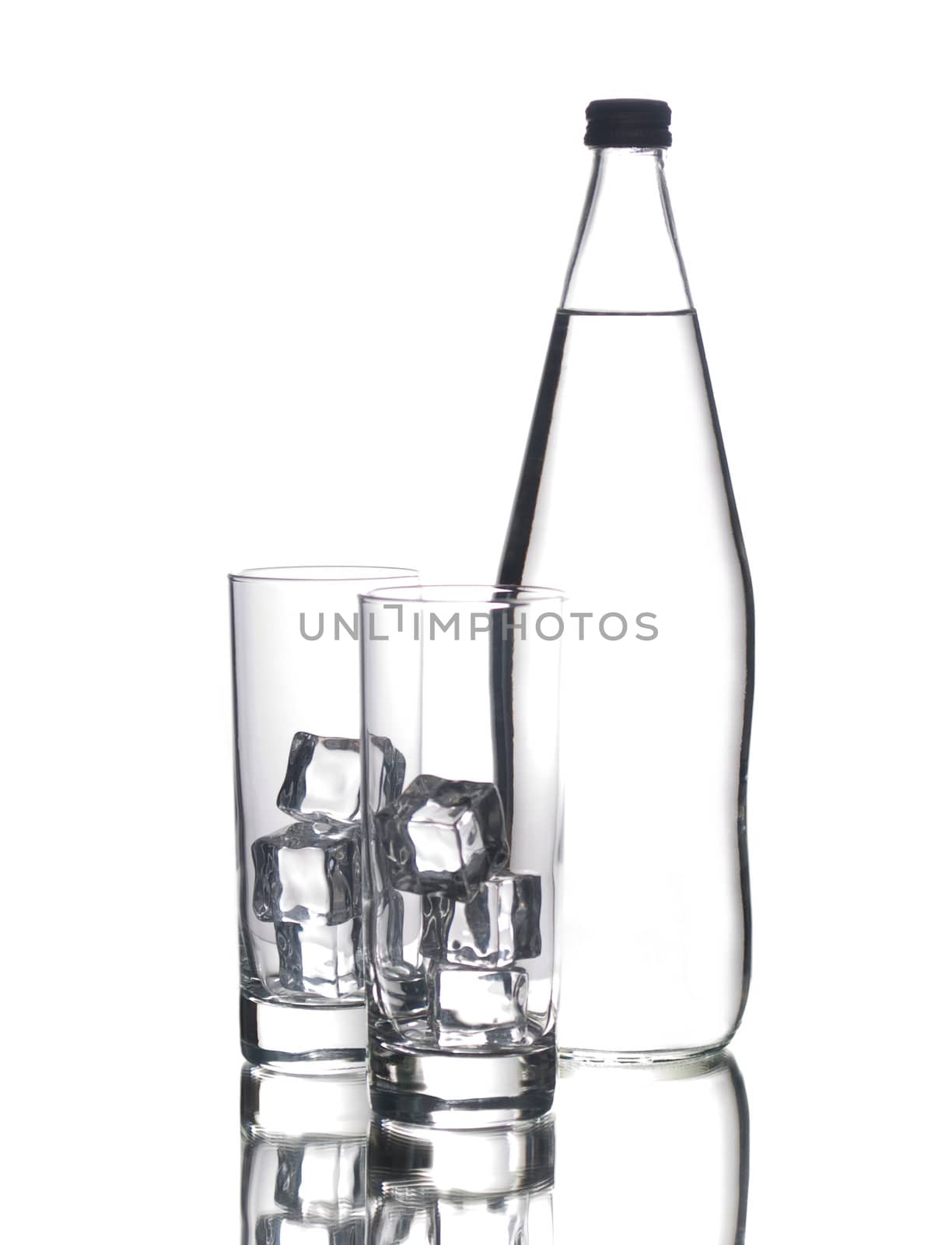 Glass bottle of water and two glasses with ice, isolated on white