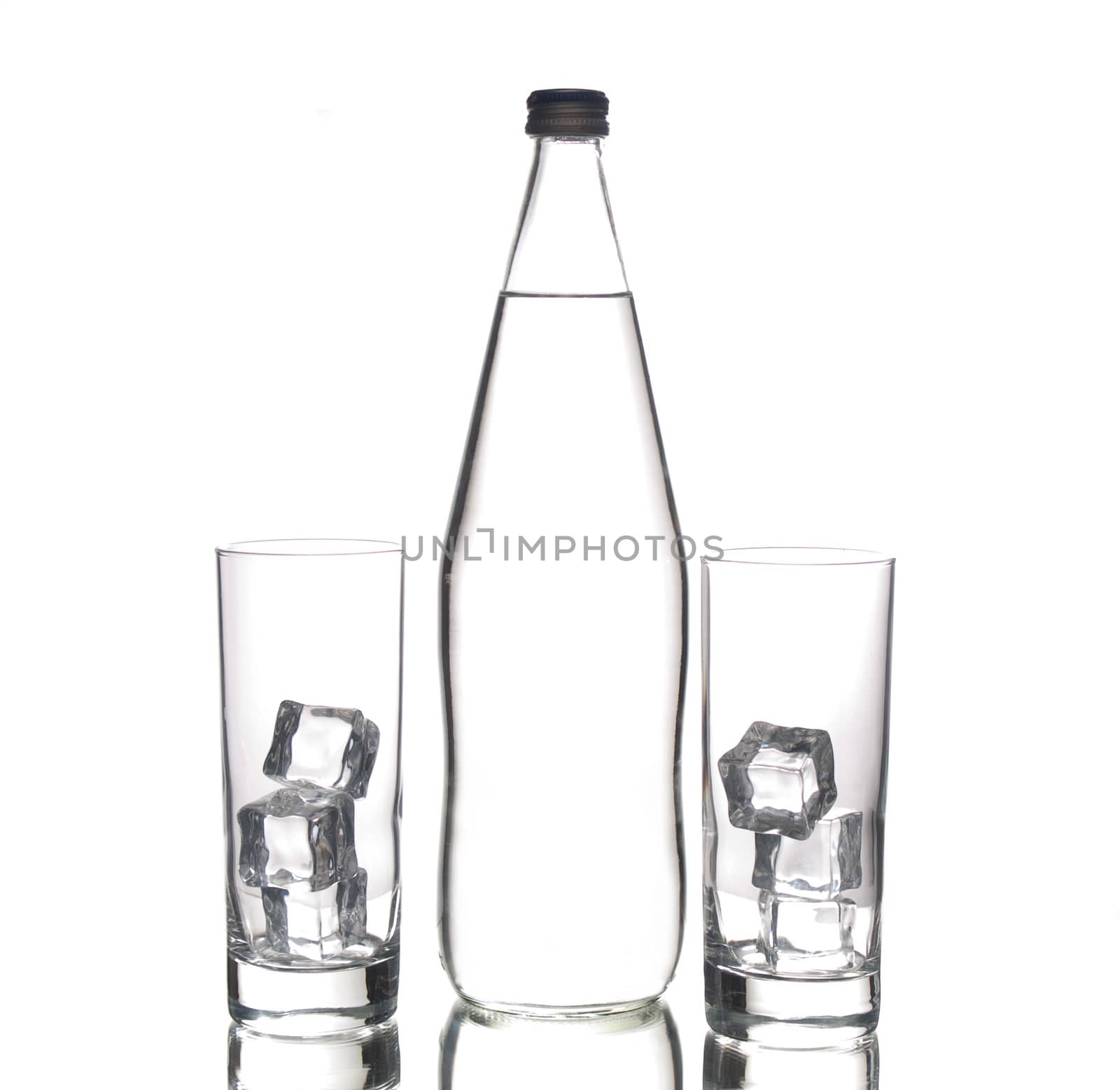 Glass bottle of water and two glasses with ice cubes, isolated 