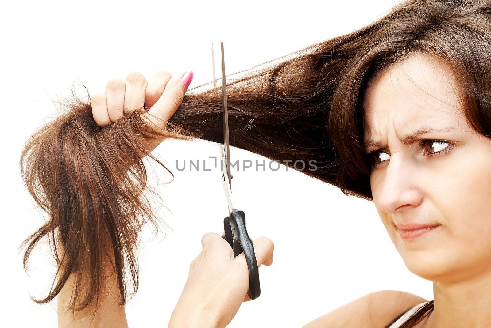 The image of a girl who was horrified cuts her hair. Isolated white.