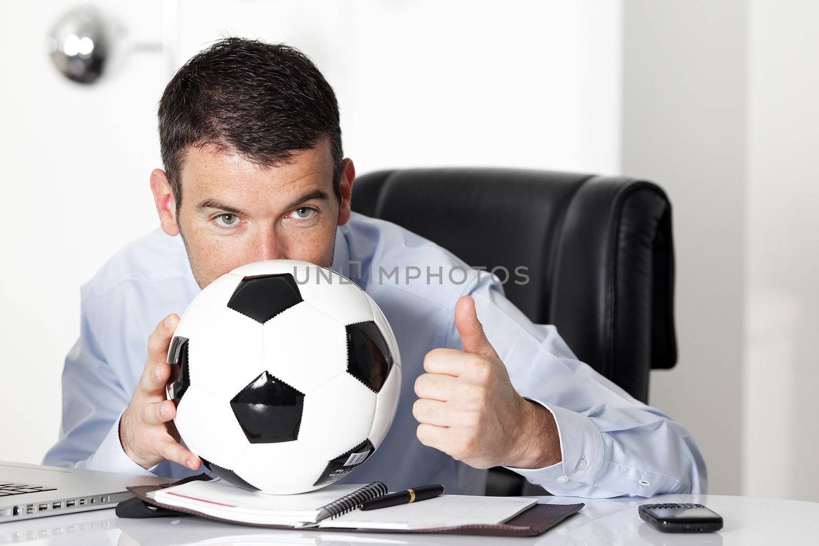 young businessman in office with computer and ball