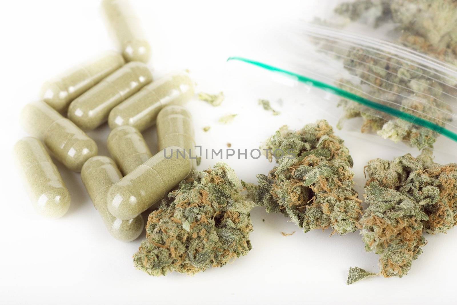 Plastic baggie of dried marijuana and green capsules.  