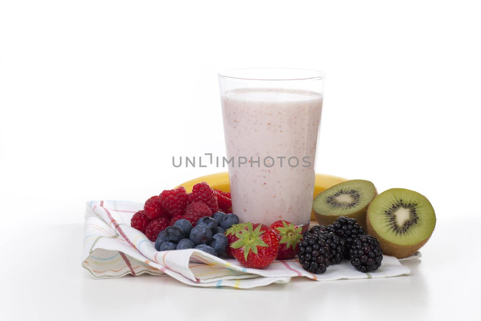 Fresh fruit surrounding fruit smoothie on white background