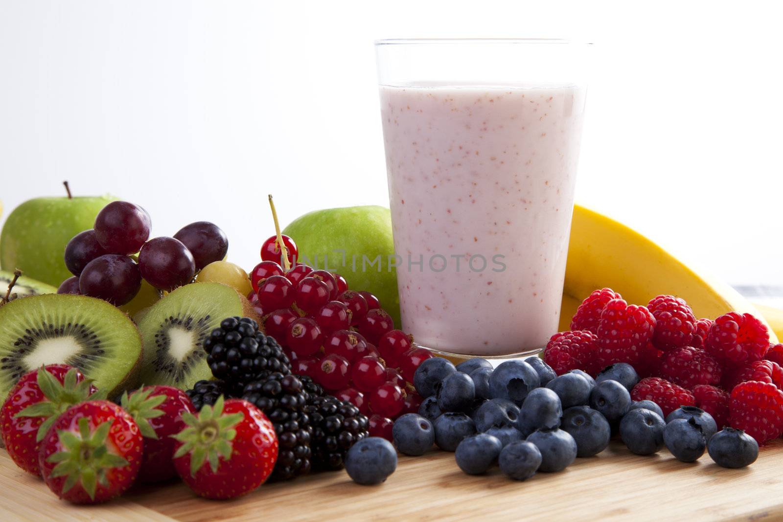 Fresh fruit surrounding fruit smoothie