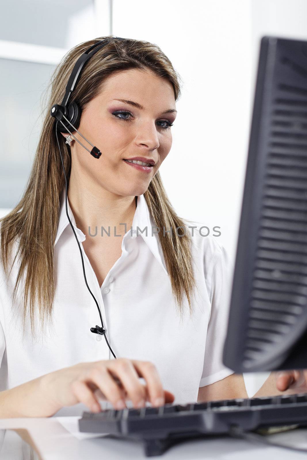 young beautiful woman with headset and computer in office