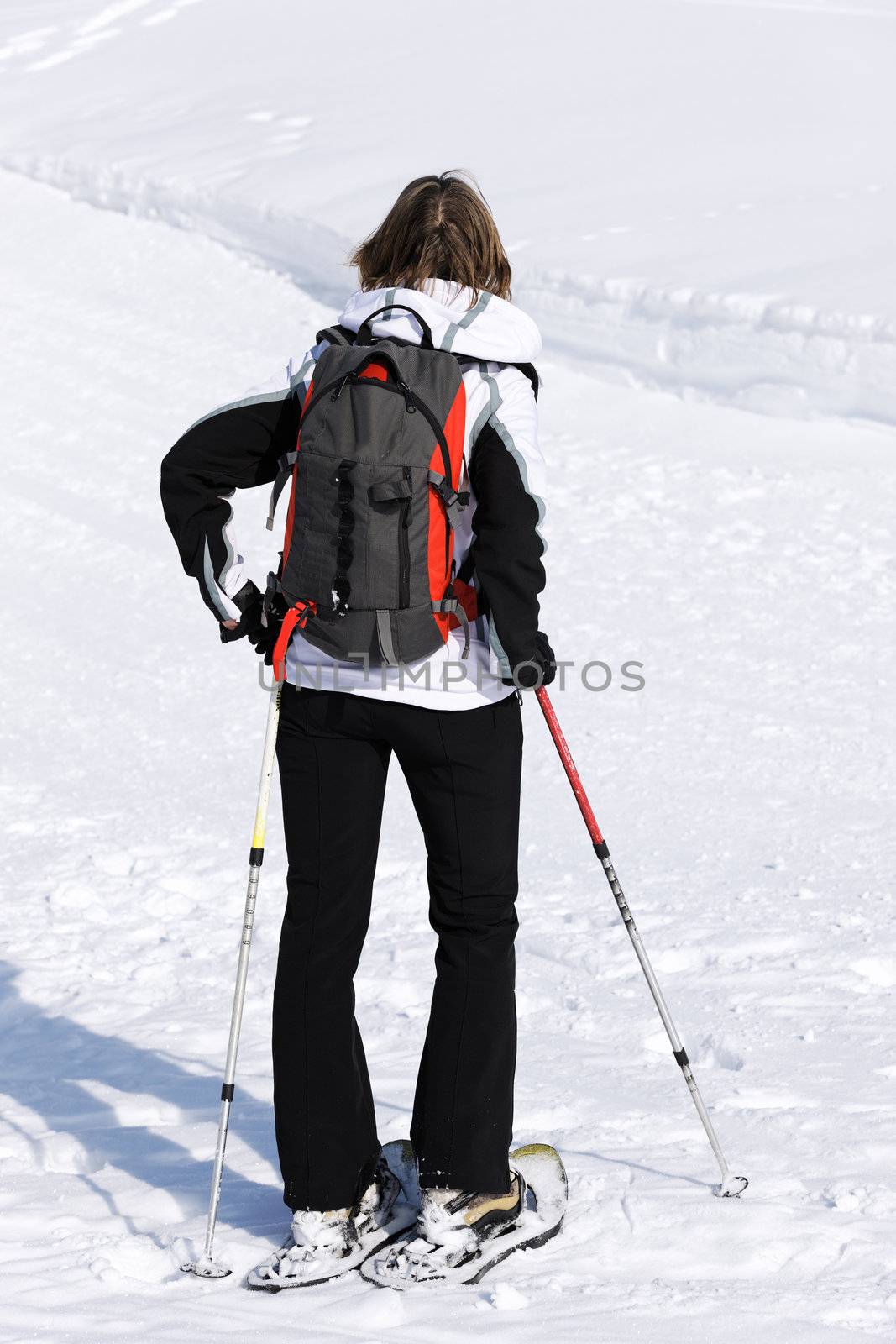 woman walking on the sow with rackets