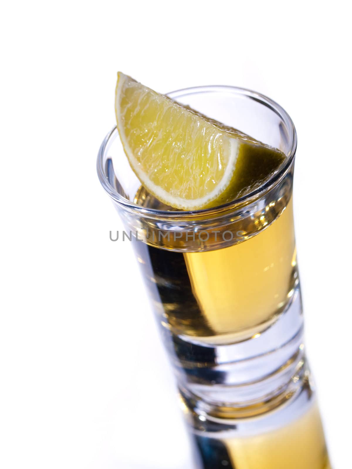 Tequila shot and lime with reflection on white