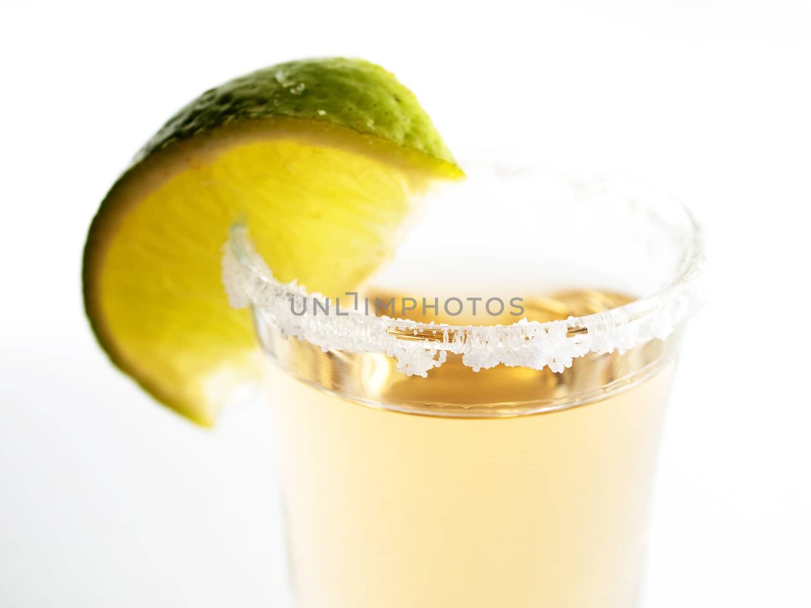 Close-up of tequila and lime on white