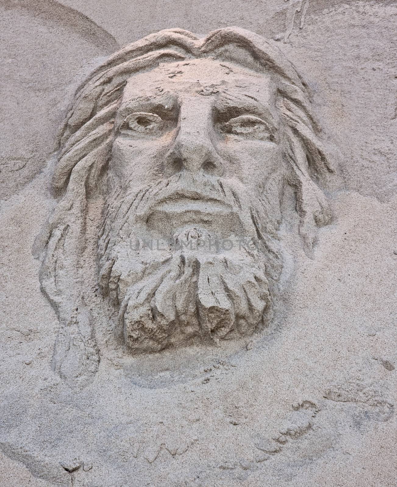 A sand sculpture at the beach of the face of Jesus