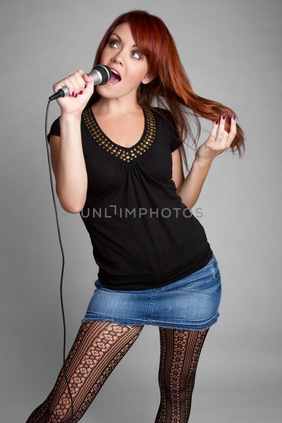 Beautiful redhead woman singing karaoke