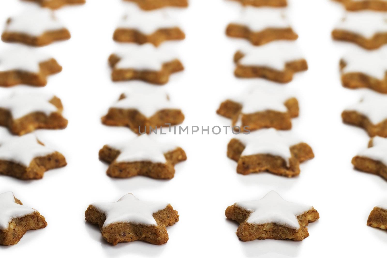 a lot of star shaped cinnamon biscuits on white background