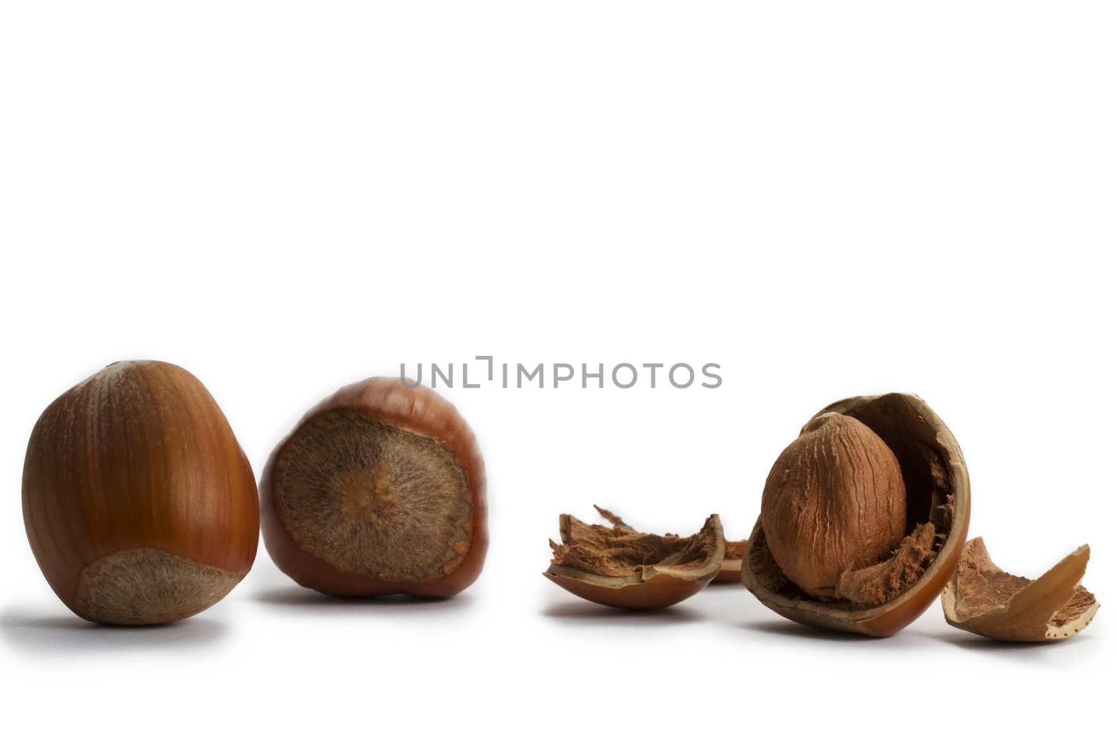 two and a cracked hazelnut on white background