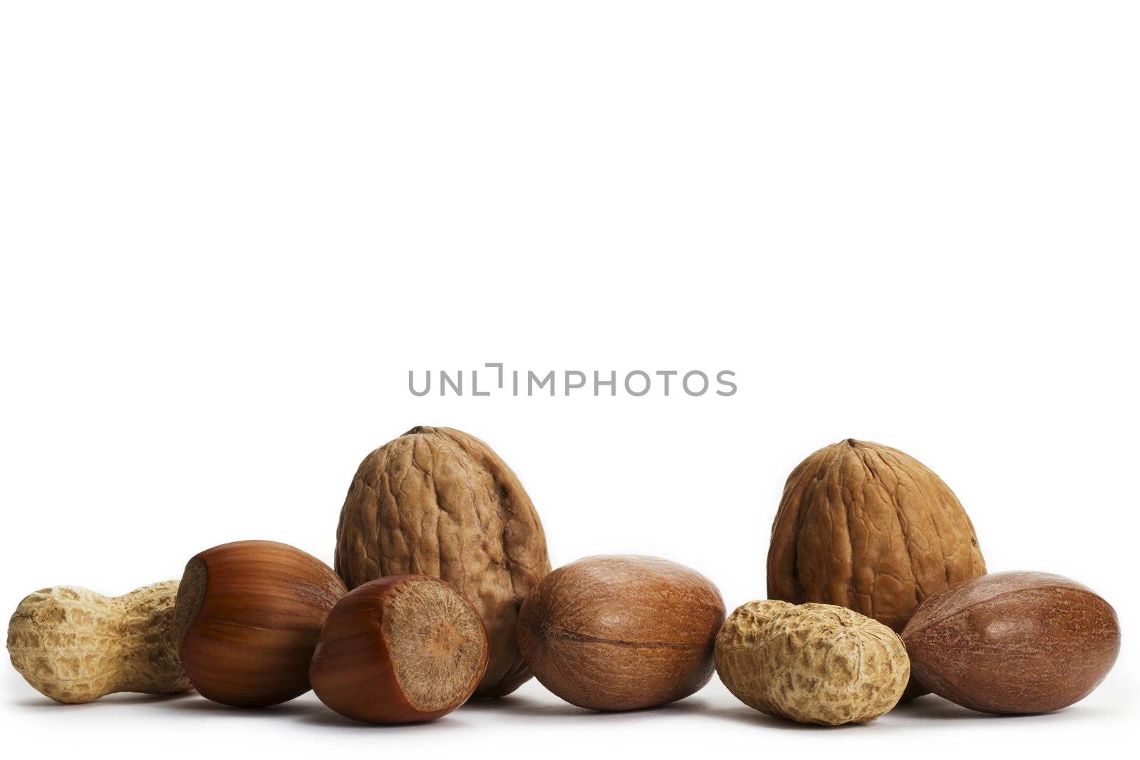 two of each pecan hazelnuts walnuts and peanuts on white background