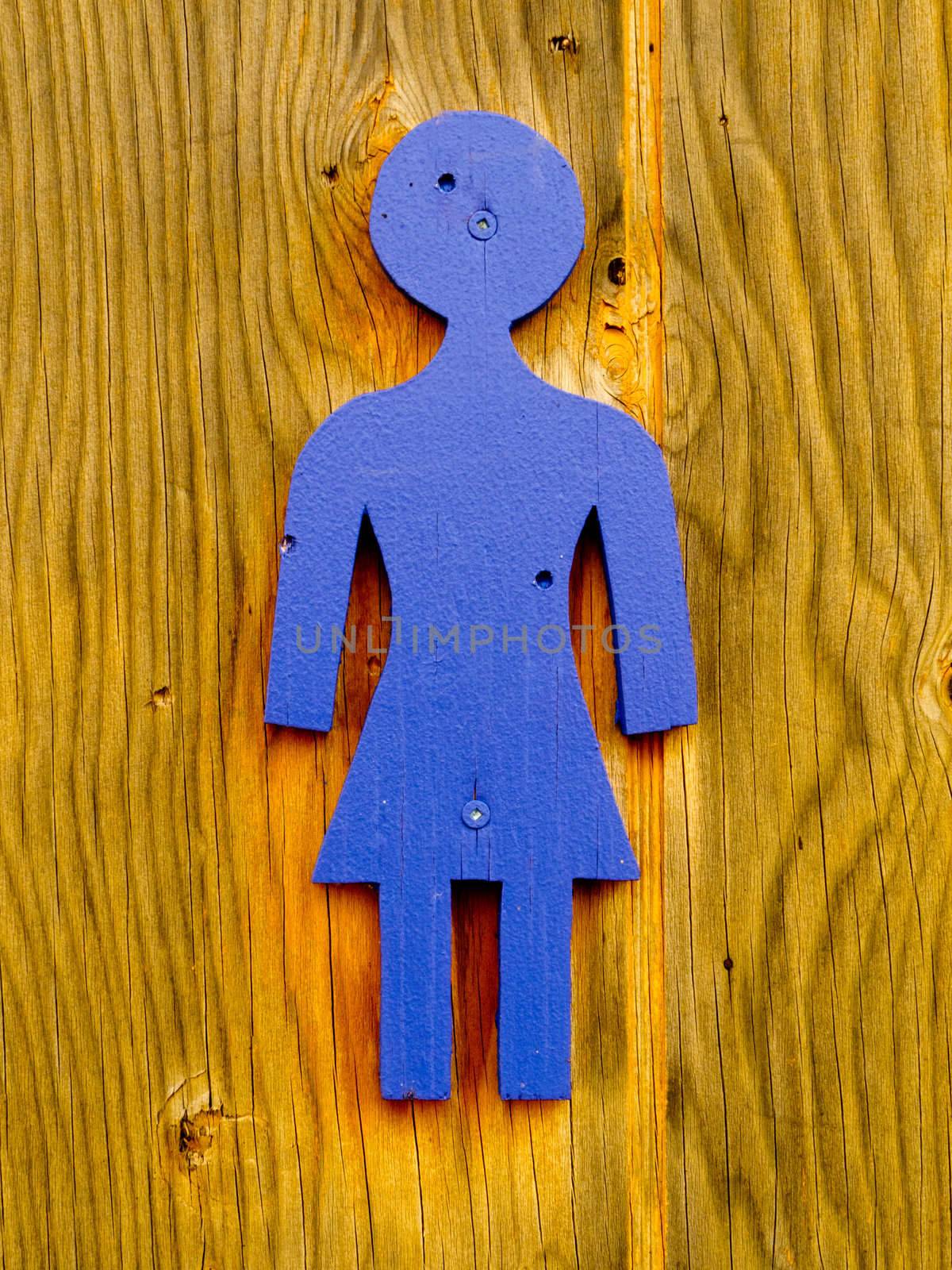 Blue Womens' restroom icon, toilet sign screwed on wooden wall