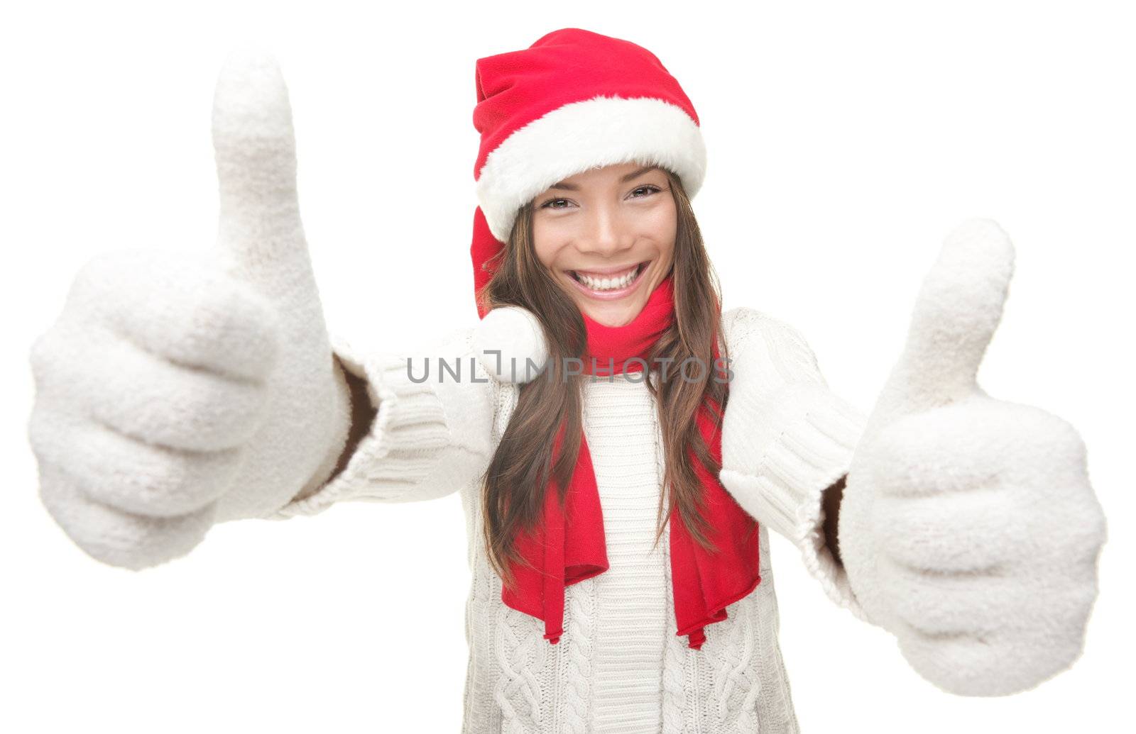 Christmas woman thumbs up success hand sign. Young smiling woman in Santa hat and warm winter sweater. Isolated on white background.Funny photo of Asian Chinese / white Caucasian female model.