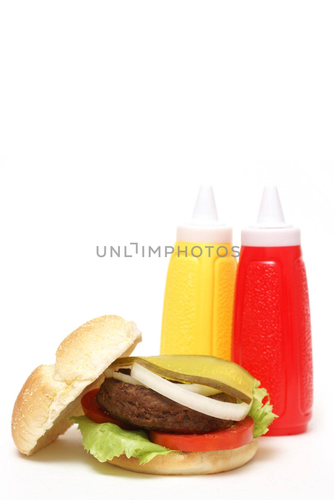 An isolated hamburger with mustard and ketchup bottles.