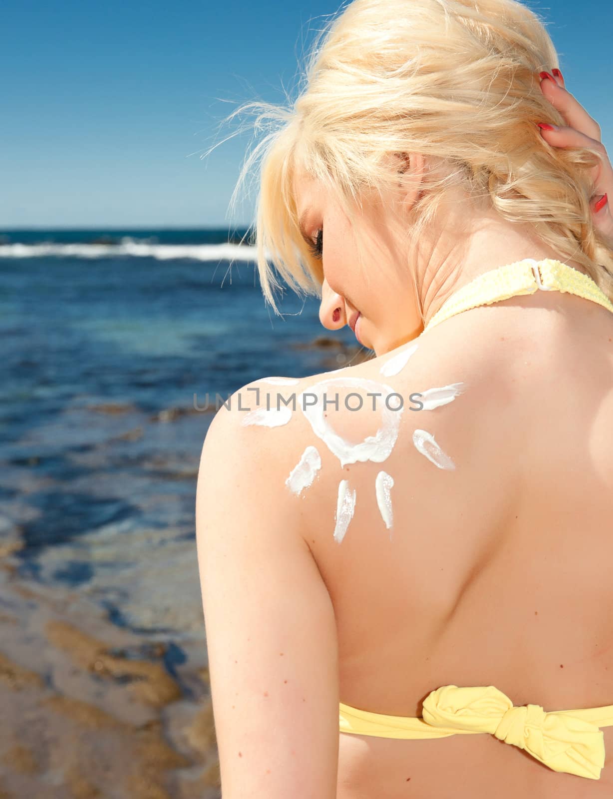 beautiful young woman with sun shape in sunscreen