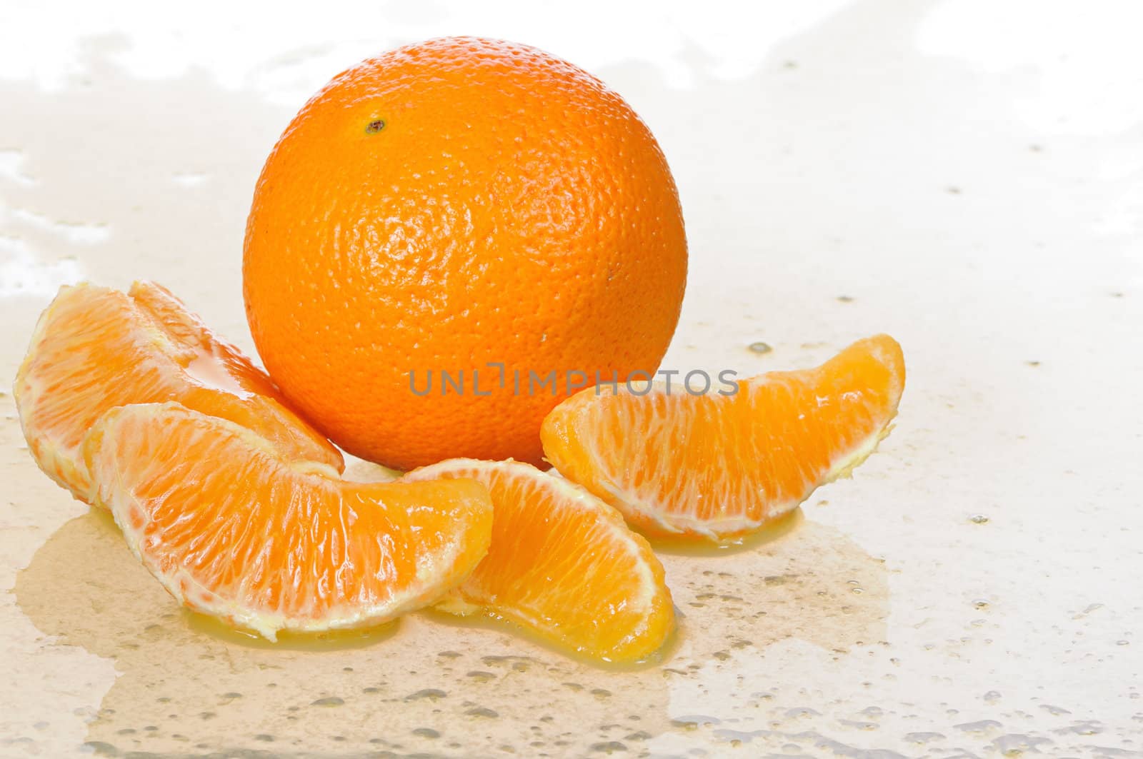 The whole orange with segments lays in juice