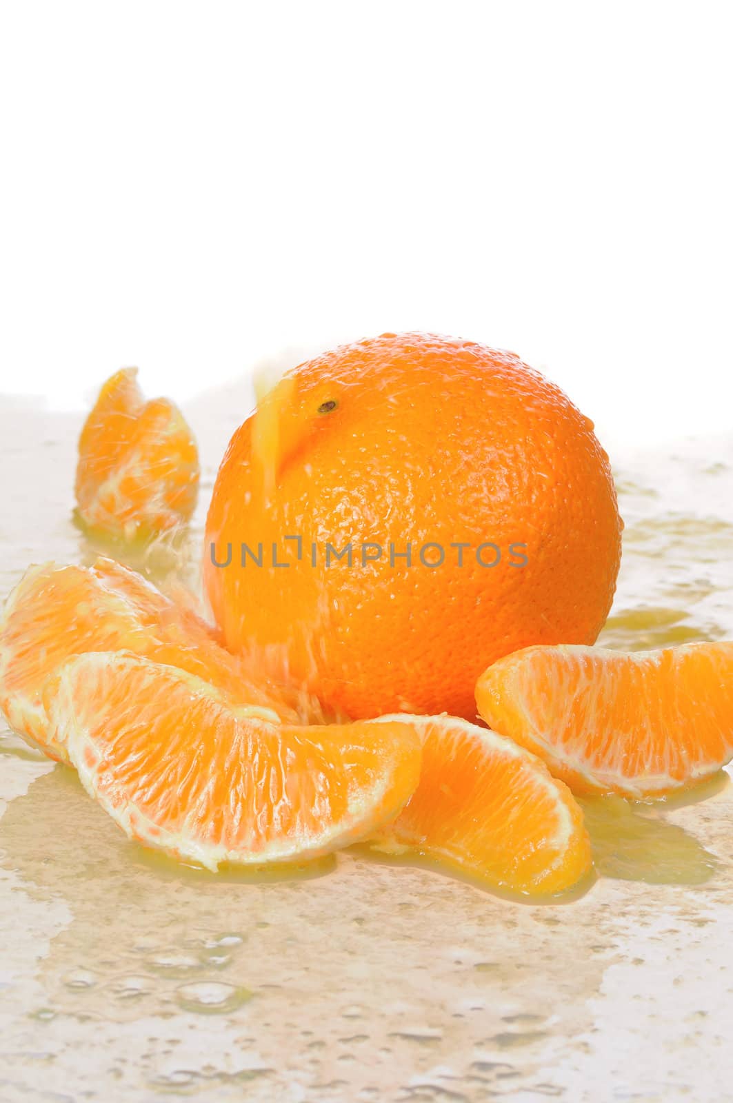 The whole orange with segments lays in juice