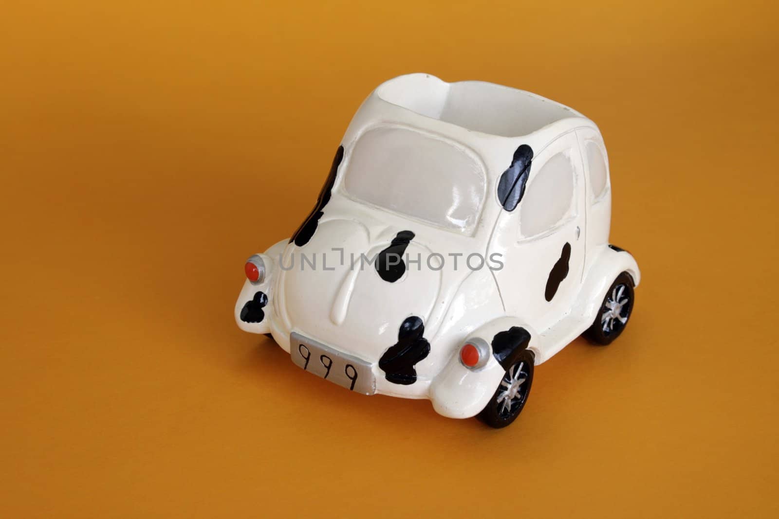 Toy ceramic car in isolated over yellow